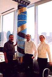 The artist, Dr Tom Hudson, and agent Natasha Deshaies in front of "Neo-rupestrian DNA double helix (gold)" painting.