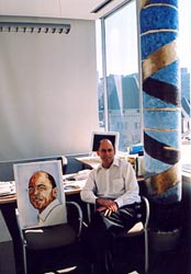 Dr Tom Hudson between his portrait and "Neo-rupestrian DNA double helix (gold)".
