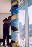 The artist installing the painting over the column in Dr Tom Hudson's office.