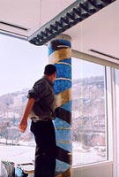 The artist installing the painting over the column in Dr Tom Hudson's office.